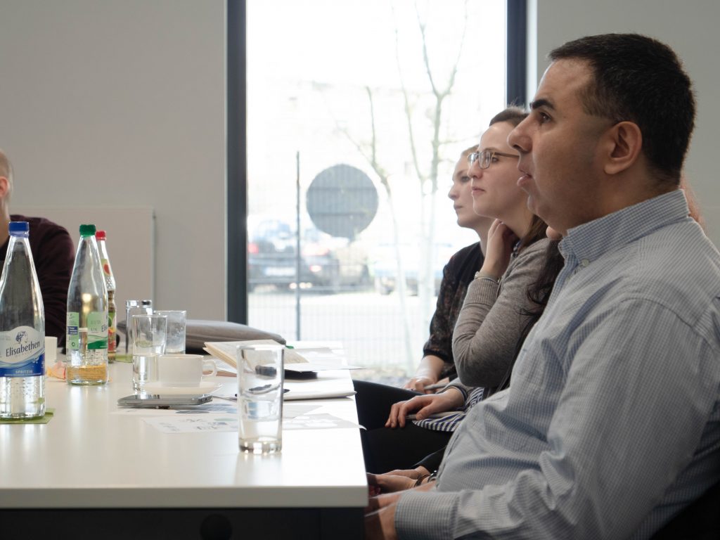 Drei Teilnehmende am Tisch des 2. Vernetzungstreffens.