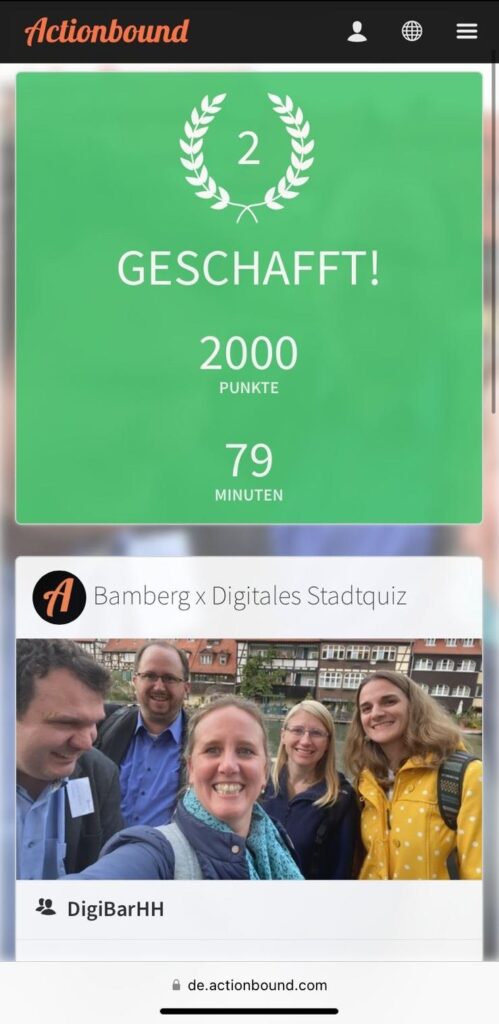 „Actionbound“: In der App Actionbound ist ein Gruppenfoto mit fünf Personen zu sehen, die lächelnd ein Selfie machen. Darüber die Anzeige: Bamberg – Digitales Stadtquiz, Geschafft – 2. Platz, 2000 Punkte, 79 Minuten.