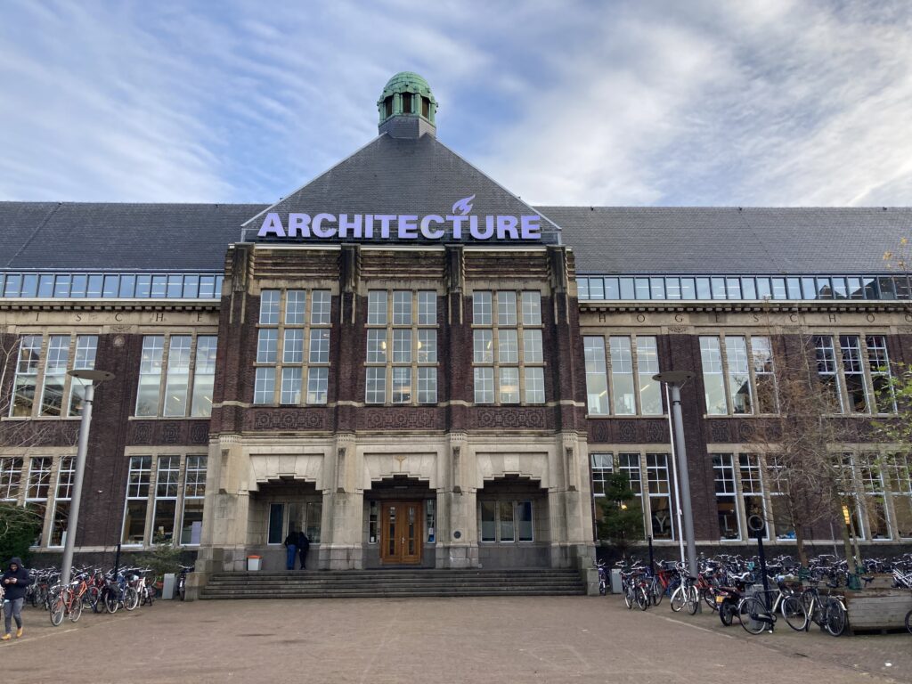 Das imposante Architektur-Gebäude der TU Delft. Davor Fahrräder. 