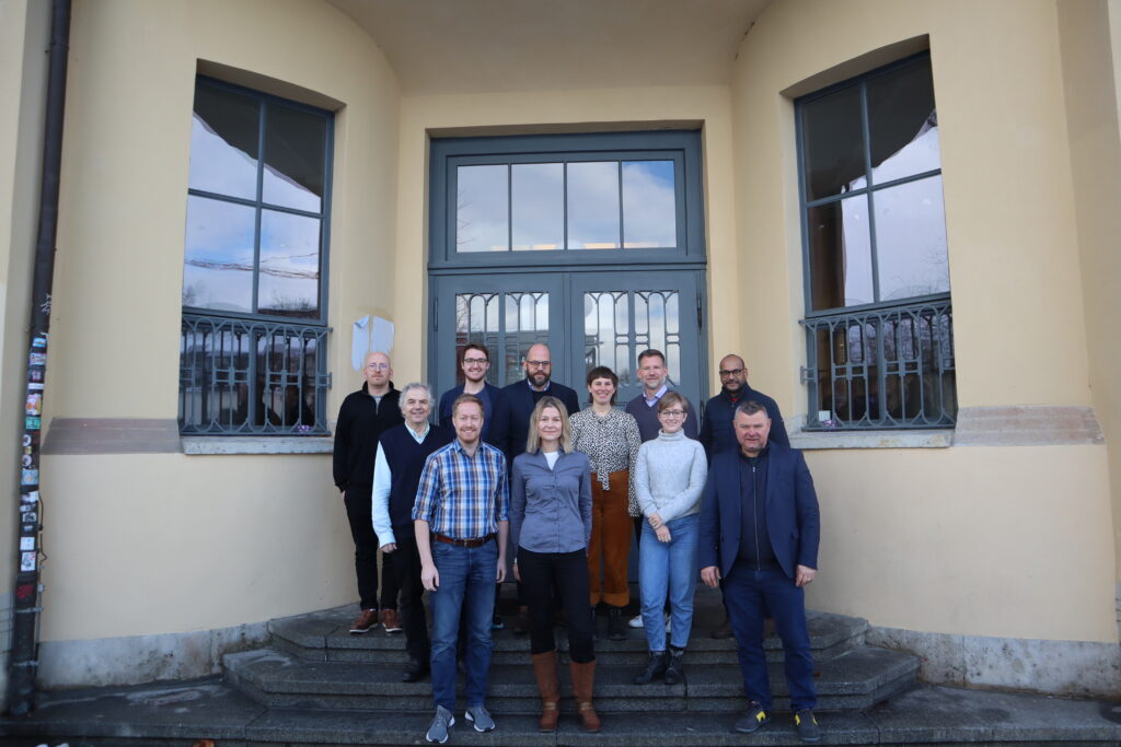 Von Links nach Rechts: Alexander Clauss, Daniel Diekmann, Markus Deimann, Sebastian Metag, Martin Lentz,Peter Rempis, Paulina Rinne, Verena Russlies, Tim Wiegers, Noreen Krause und Konrad Faber auf einer Treppe vor der Bauhaus-Universität Weimar.  