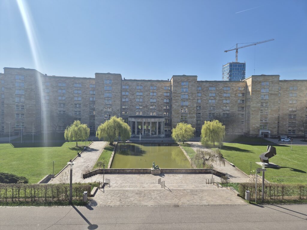 Eine Universitätsgebäude und ein Park bei Sonnenschein.